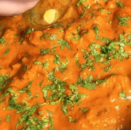 Delicious butter chicken served with rice and naan bread