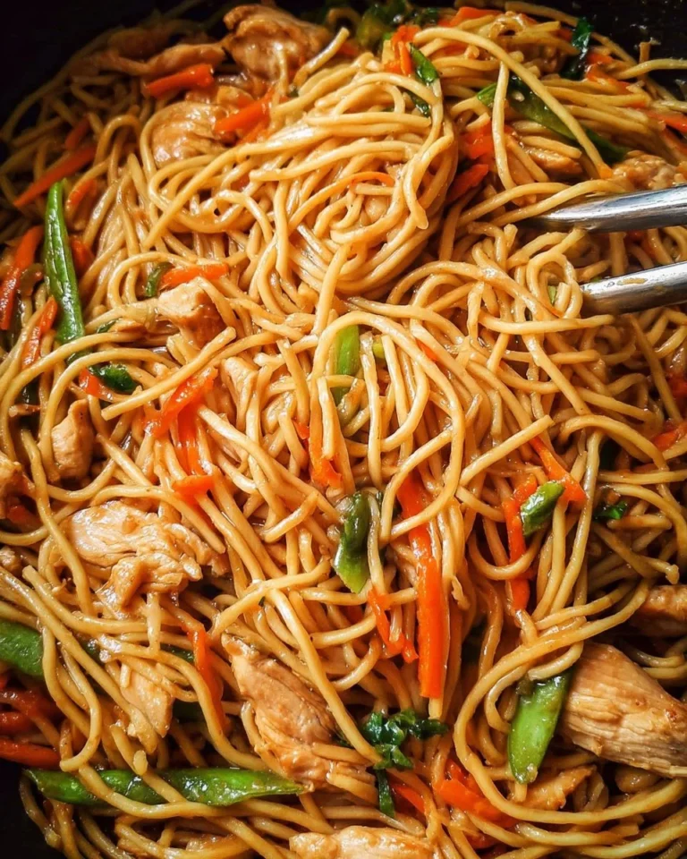 Delicious homemade chicken lo mein served in a bowl with colorful vegetables.
