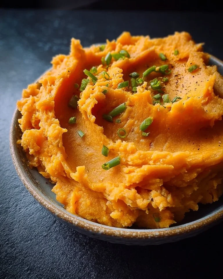 Creamy mashed sweet potatoes served in a bowl with a garnish