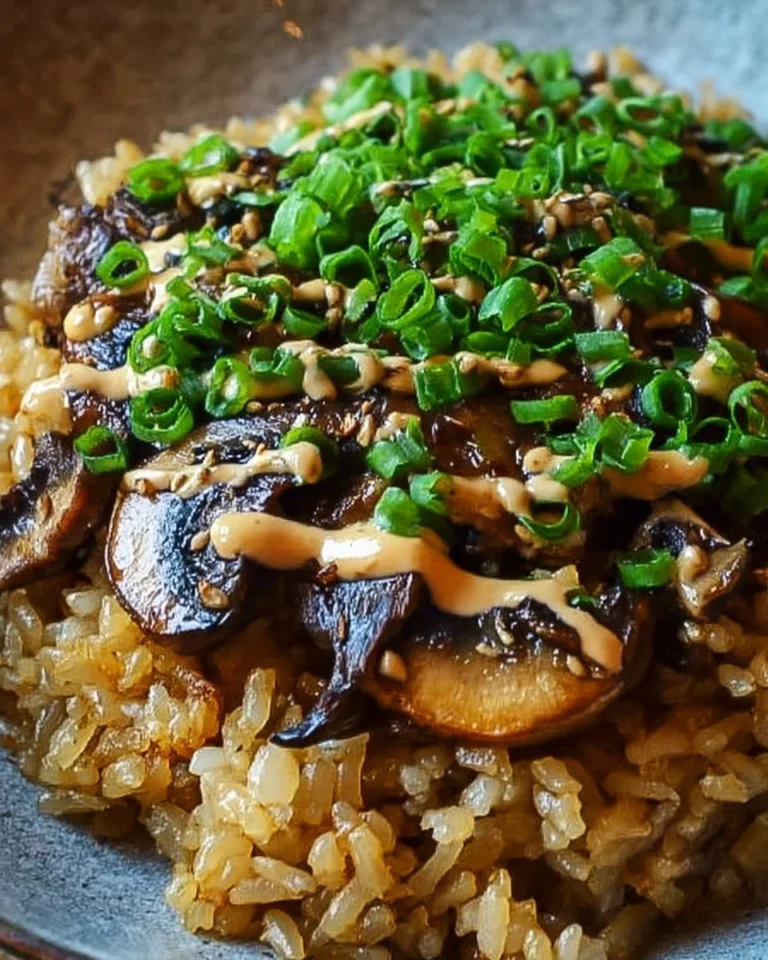 Plate of crispy rice topped with miso mushrooms and garnished with herbs
