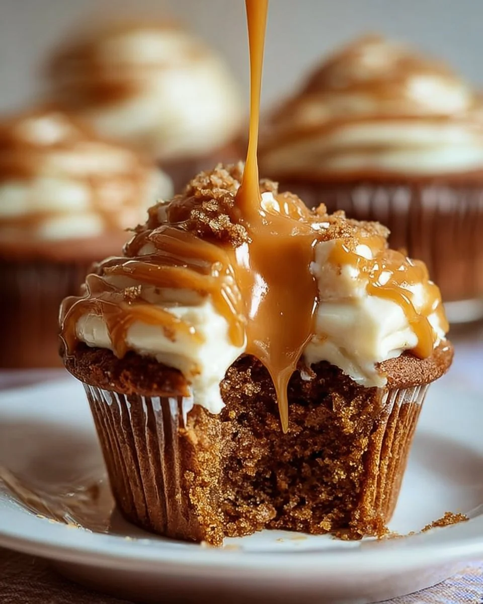 Rich sticky toffee pudding cupcakes topped with caramel sauce and whipped cream